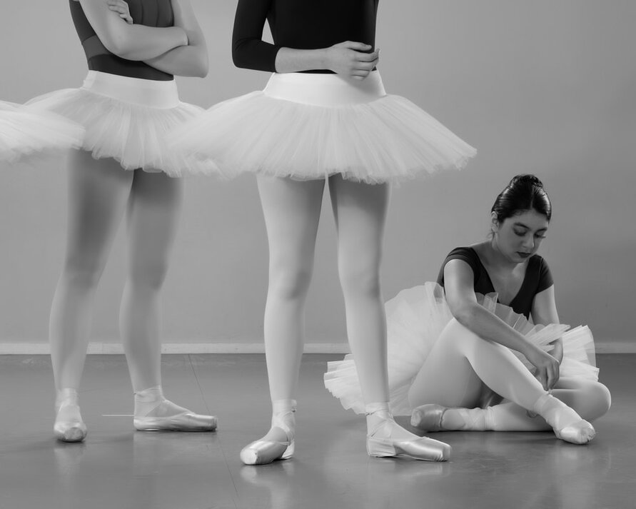 Ballet dancer tying her shoe